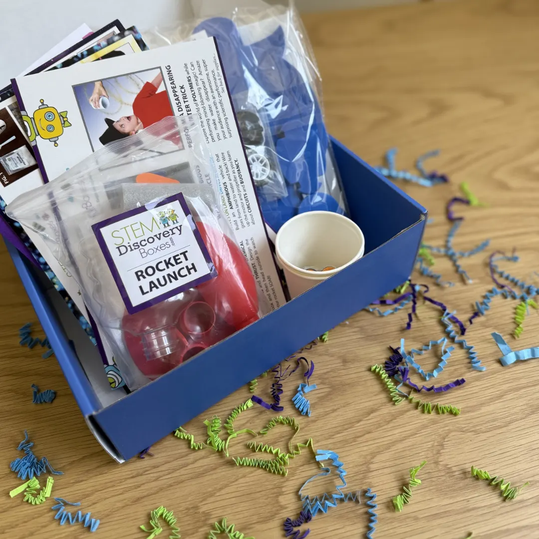 A real open blue STEM Discovery Box with its three projects and all the included supplies laid out