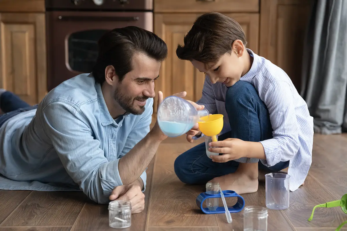A parent and child doing a science project at home
