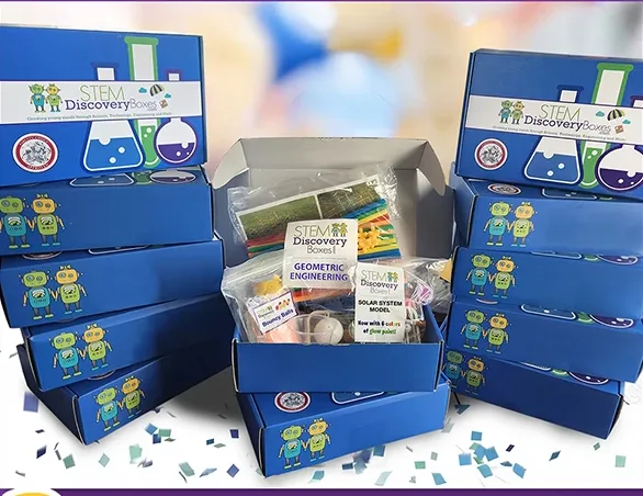 Stacks of blue boxes around one open box showing its pre-portioned project bags, with confetti scattered around them.