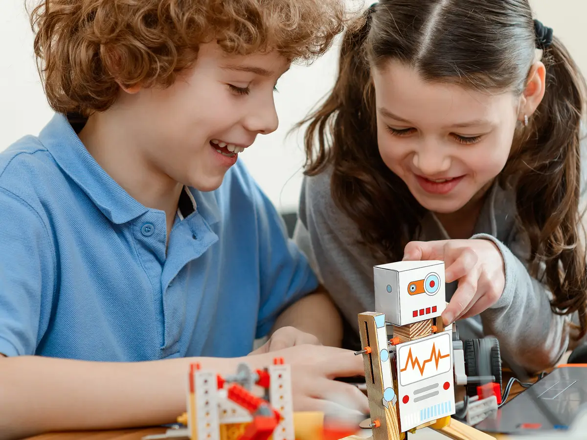 Two kids building a small robot project together