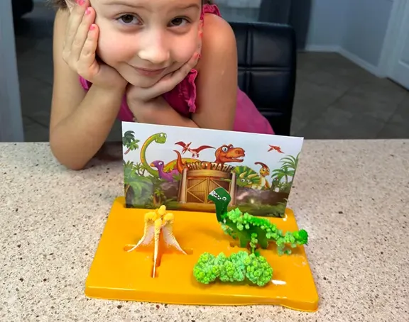 A girl with the dinosaur crystal garden she grew