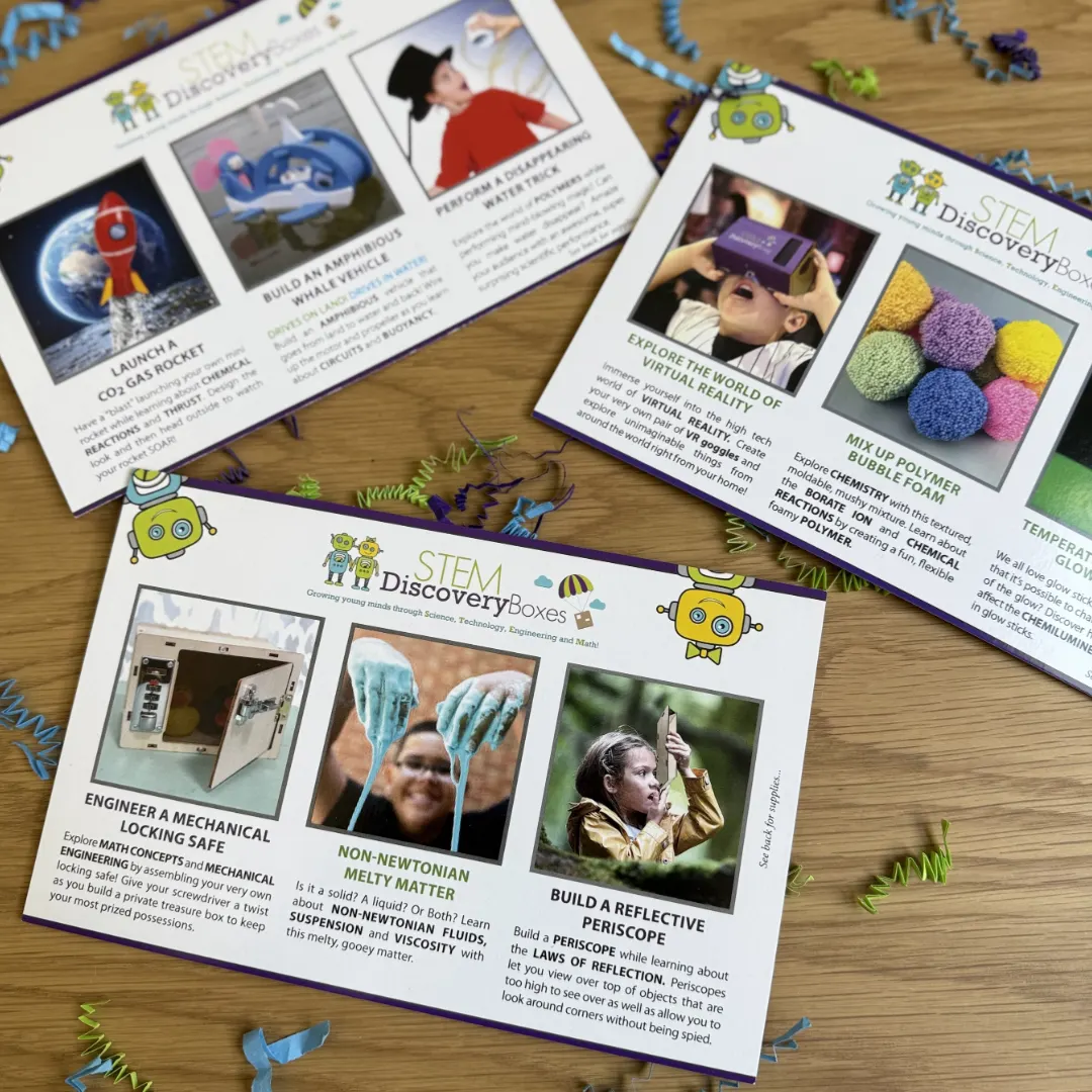Three STEM Discovery Boxes project cards fanned out on a wooden table, each card showing three projects with its own written science lesson