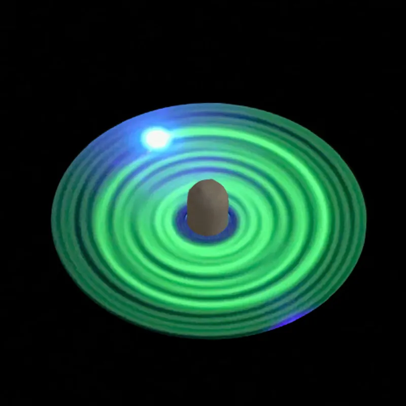 A spinning top glowing green on black, its spin drawn as rings of light
